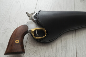 Old black powder cap and ball gun in leather holster