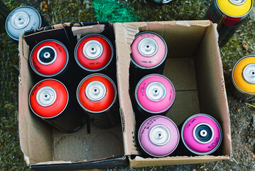 Colorful graffitty spray cans in a box