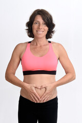 Fototapeta na wymiar pregnant woman with sportswear and sign of heart on her belly isolated on white background,