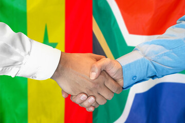 Handshake on Senegal and South Africa flag background. Support concept.