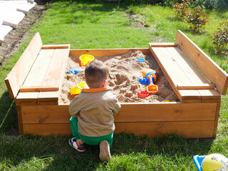 A child spends time playing in the sandbox