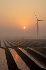 Wind power and solar power plants at sunrise and sunset