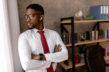 Portrait of handsome african business man with red tie and black glasses in the office