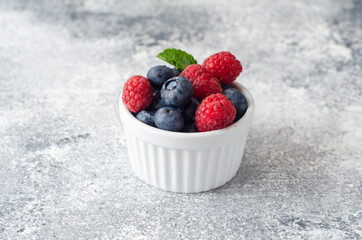 Fototapeta na wymiar raspberries and blueberries in a bowl