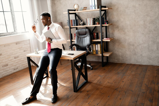 Portrait of handsome african business man with red tie and black glasses in the office