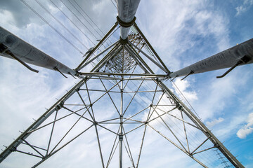 Outdoor power transmission tower under the blue sky and white clouds