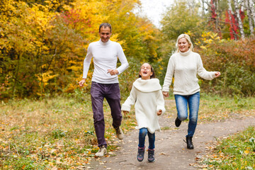 family, childhood, season and people concept - happy family in autumn park