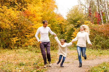 Naklejka na ściany i meble family, childhood, season and people concept - happy family in autumn park