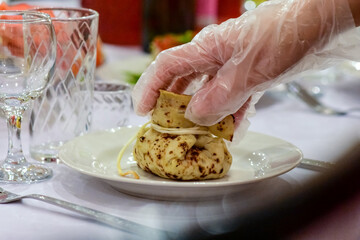Table setting in a cafe. Bag of pancakes with filling on a plate.