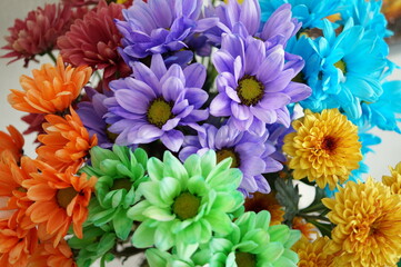 Top view of a bouquet of multi-colored chrysanthemums: orange, green, blue, lilac