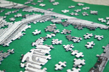 Details of the puzzle close-up in the process of Assembly, spread out on a green Mat. Puzzle in shades of grey
