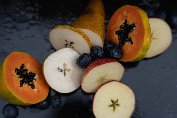 Fruits close up on black stone background