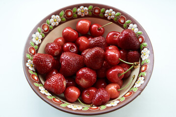 Cherries and strawberries in a ceramic bowl