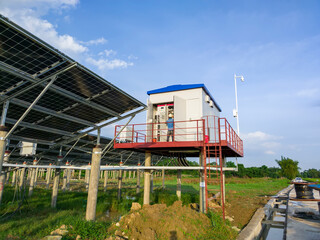 Workers repair and install a transformer system that generates electricity from solar panels
