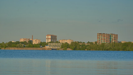 View of residential buildings in golden light on the Voronezh reservoir from the right bank in summer