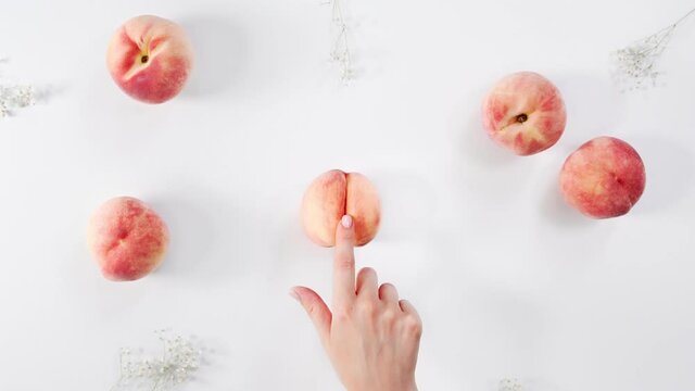 Female hand stroking fruit peach imprinting a petting. Masturbation concept and massage of sexual caresses. Abstract image of the vagina. Sex education. Imitation sex. 