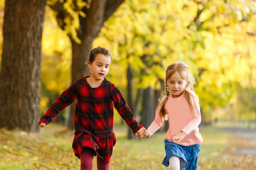 Two little girl friends schoolgirl in the park.