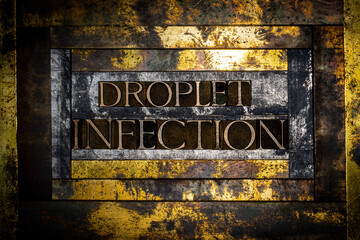 Droplet Infection text formed with real authentic typeset letters on vintage textured silver grunge copper and gold background