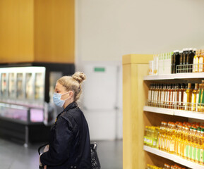 Supermarket shopping, face mask and gloves,Woman choosing a dairy products at supermarket