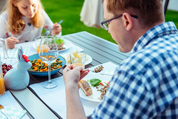 Happy family eating healthy dinner on terrace at home