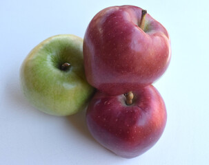 A group of three apples on a white background