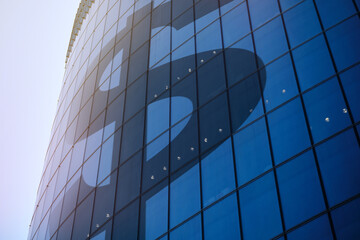 Abstract sign of the US dollar on the facade of a skyscraper.