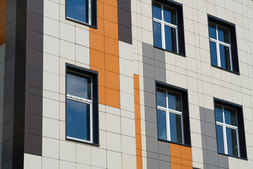 facade of a modern building on a bright Sunny day, siding and Windows, beautiful exterior of the new building