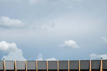 black spotlight install to top of yellow and black metal sheet building in bottom with blue sky cloudy weather stock photo