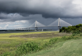 Storm Clouds roll in above the Arthur Ravenel Jr Bridge in Charleston, South Carolina as pleasurer  boats scurry for a safe harbor