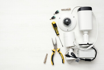 Modern white security cameras and work tools on the table background. Video surveillance concept...