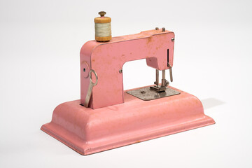 Antique children's toy sewing machine isolated on a white background