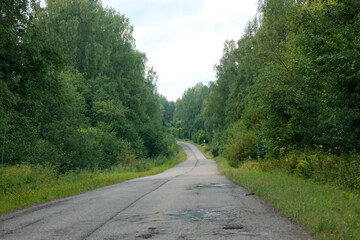 old asphalt country road in the forest, Russia