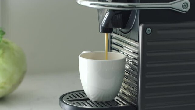 milk is pouring into cup from coffee machine at home Spbd. cappuccino automatic making. morning household. concept aromatic caffeine at home. nobody on footage.
