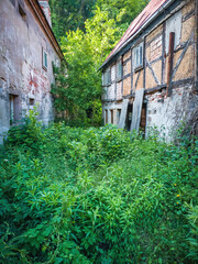 Zwei verfallene Häuser - Zwei alte, heruntergekommene, verfallene und verlassene Häuser und die mit Gras und Unkraut überwucherte Lücke zwischen ihnen.
