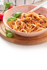 Pasta Bolognese. Tagliatelle with homemade bolognese sauce of minced meat, tomatoes, celery, carrots and spices in a bowl on a white background. Italian Cuisine. Free space for text