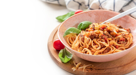 Pasta Bolognese. Tagliatelle with homemade bolognese sauce of minced meat, tomatoes, celery, carrots and spices in a bowl on a white background. Italian Cuisine. Free space for text