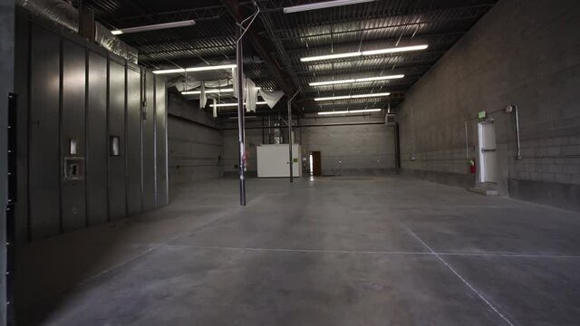 Dolly shot of grey big warehouse. Interior video of brick wall warehouse.