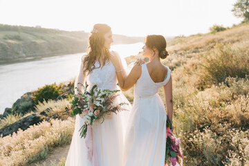 Lesbian wedding couple in white dresses - obrazy, fototapety, plakaty
