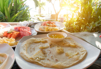Breakfast, pancakes and fruits, is served on the outdoor terrace, overlooking the   and tropical plants. Indonesia