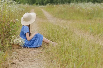 Fotobehang 10 jaar oud meisje in de blauwe jurk en de mand met bloemen op het platteland © Albert Ziganshin
