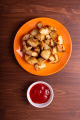 fried potato chips and ketchup on the brown wooden background