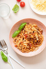 Spaghetti bolognese. Pasta with homemade bolognese sauce of meat, tomatoes, celery, carrots and spices in a bowl on a white served table top view. Italian Cuisine.