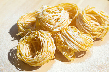 Fresh pasta food. Homemade Italian pasta cooked on a wooden background in a rustic style decorated with egg and flour.