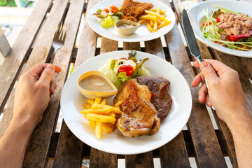 First-person view of a guy eating food in a summer cafe.