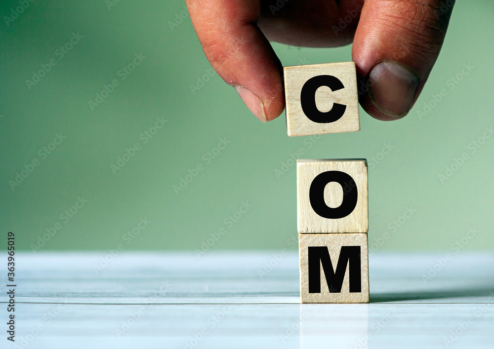 Poster the hand puts the cube block with the inscription com