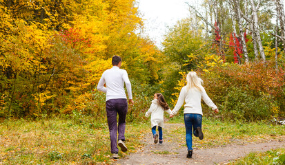 Obraz premium family, childhood, season and people concept - happy family in autumn park
