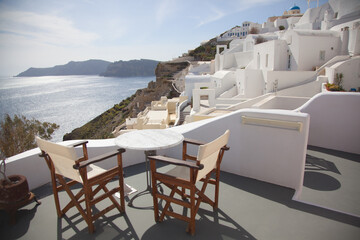 Fototapeta premium two chairs and a table on the terrace, santorini island greece