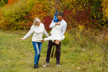 Picture of lovely family in autumn park, young parents with nice adorable daughter playing outdoors, have fun on backyard in fall, happy family enjoy autumnal nature