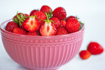 ripe strawberries in a pink bowl close-up. background with fresh ripe strawberries.