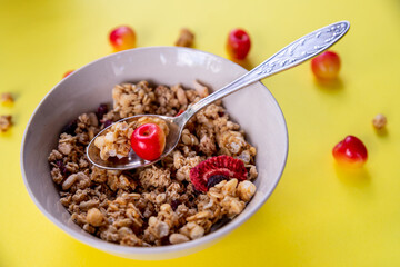 delicious and healthy wholegrain muesli breakfast, with lots of dry fruits, nuts, grains and a fresh cherries.oat flakes and fresh berries .Food made of granola and cereal